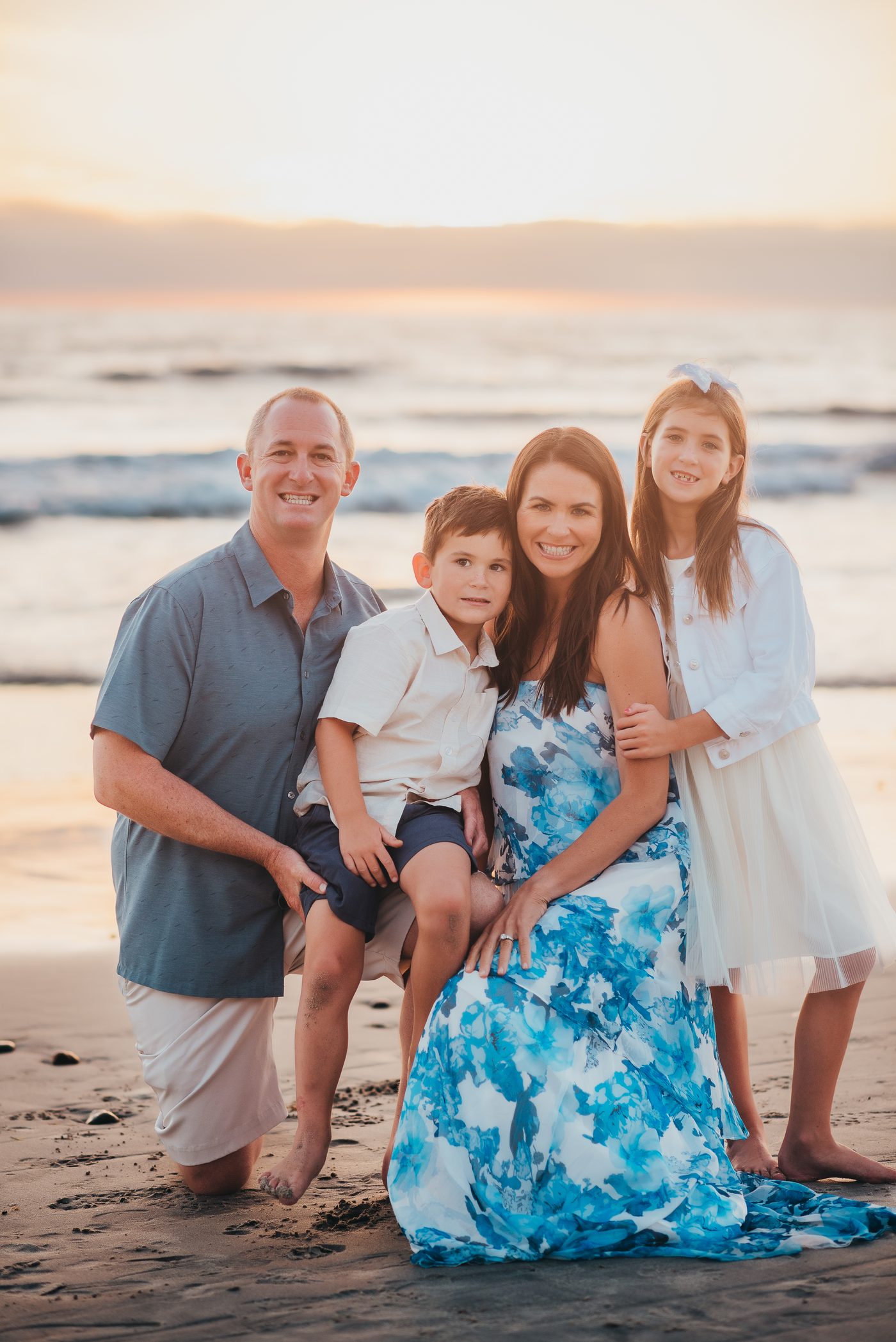 Jon Shea with his wife and two kids on the beach at sunset